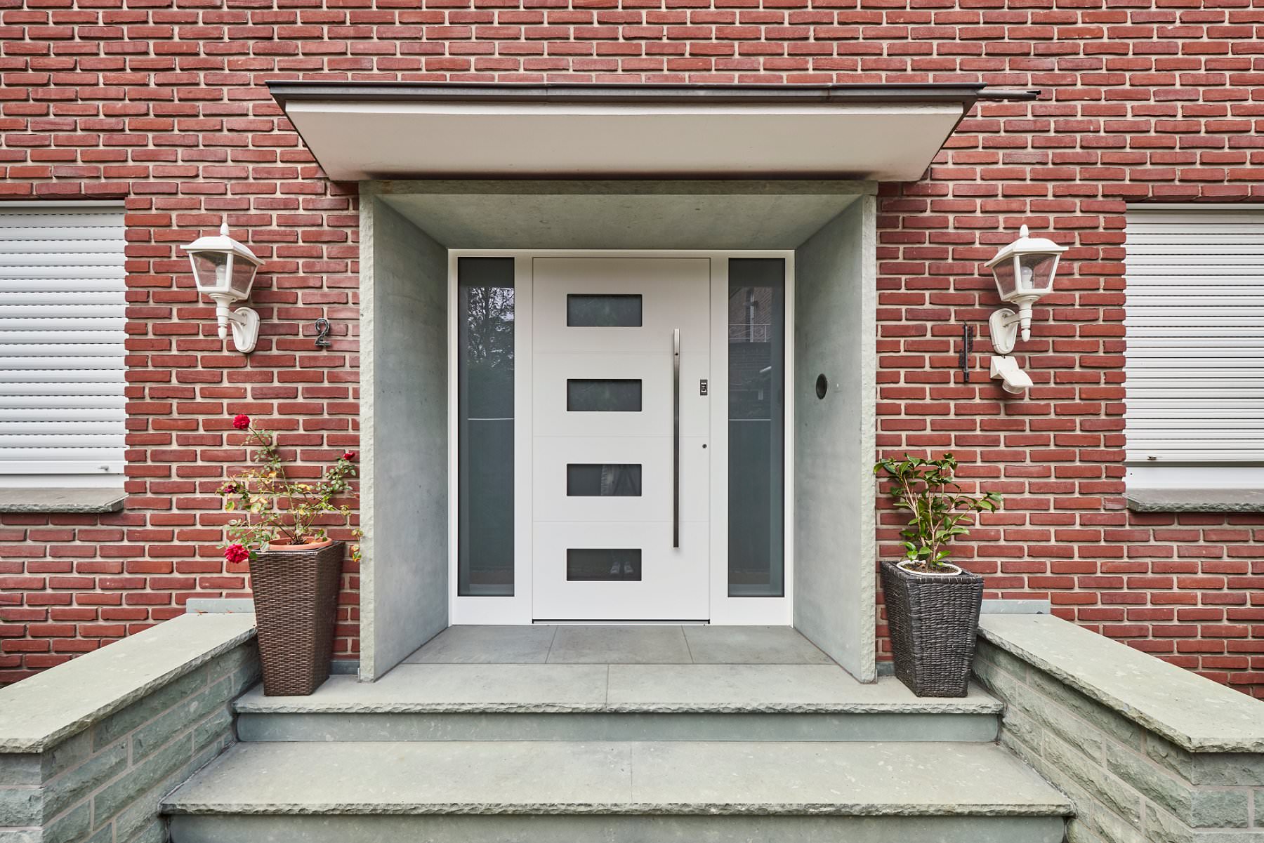 Weiße Haustür im Bauhaus-Stil mit kleinen Fenstern