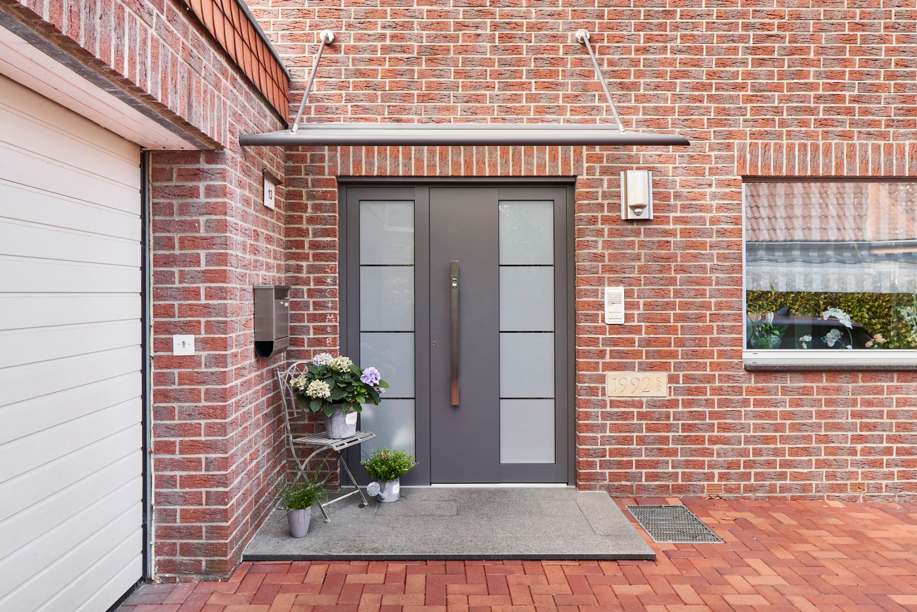 Glas-Vordach und Haustür sind passend aufeinander abgestimmt