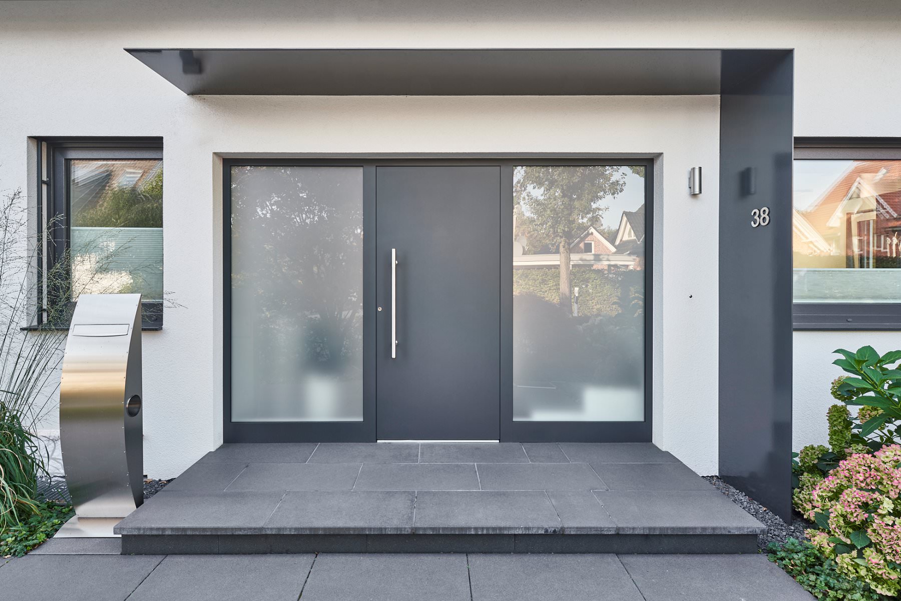 Haustür in Anthrazit mit modernem Überdach in L-Form